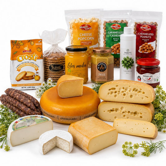 Assorted cheeses and packaged snacks on a white surface with greenery. Made for midsummer fest Ligo.